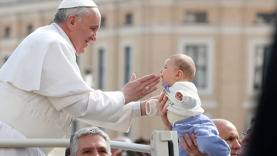 YO TE BENDIGO... El Papa besa a un bebé, esta mañana en la Plaza de San Pedro. EFE