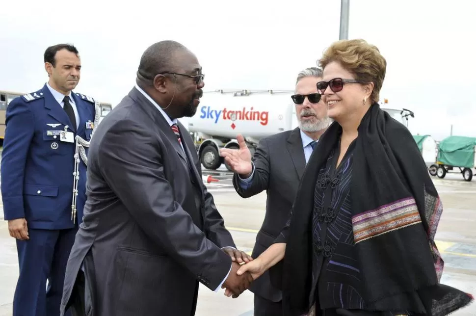 EN SUDÁFRICA. El ministro de Trabajo sudafricano recibe en el aeropuerto a la presidenta brasileña. REUTERS