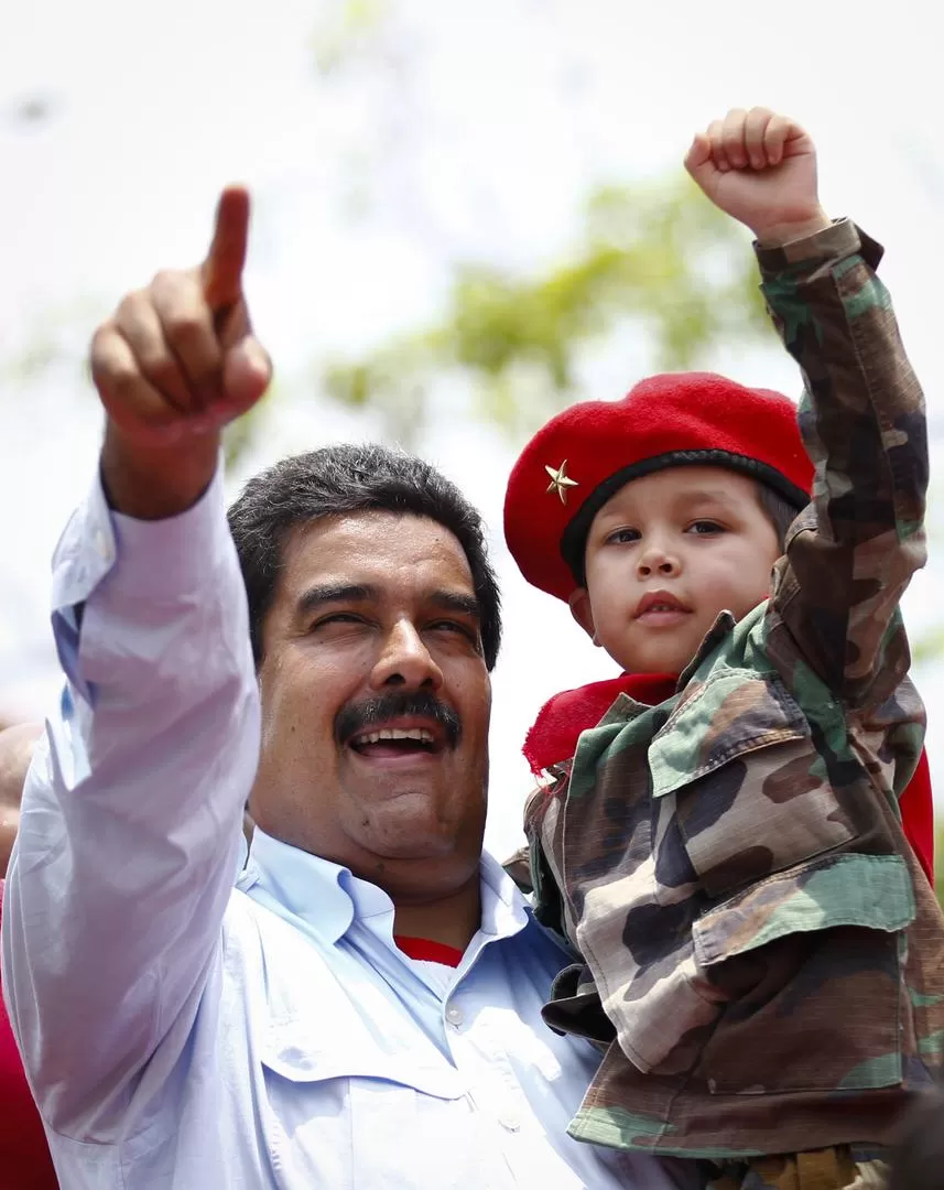EN BARINAS. Maduro, con un niño en sus brazos, saluda a los chavistas. REUTERS