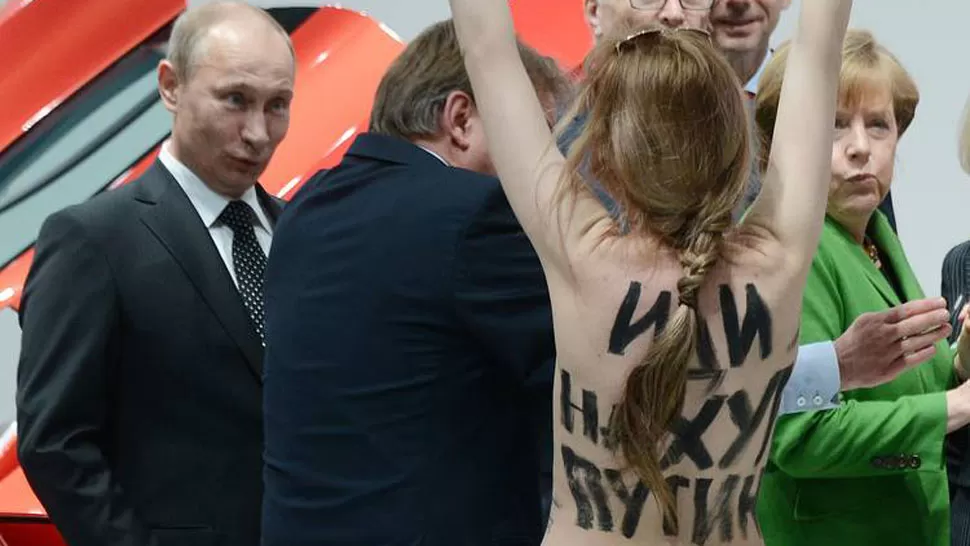 SORPRESA. Ante la presencia de mujeres en topless, Putin sólo atinó a sonreir. FOTO TOMADA DE CLARIN.COM