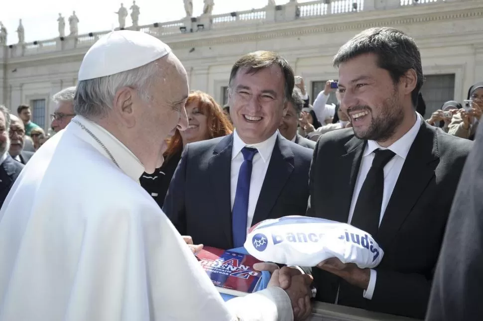 REGALOS. El Papa recibe obsequios de Matías Lammens (derecha) y Leonardo Lipera, directivos de San Lorenzo. REUTERS 
