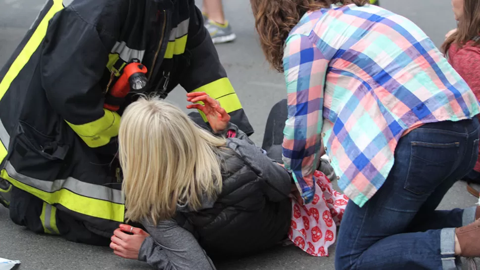 ENSANGRENTADA. Una mujer herida es auxiliada en el medio de la calle. REUTERS