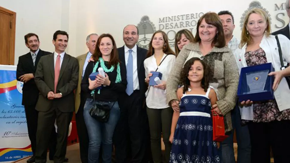 DISTINCIÓN. El ministro Manzur rodeado por donantes y una niña receptora.
