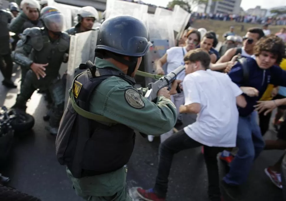 EN CARACAS. La policía antimotines dispersa a manifestantes de la oposición, que exigían un nuevo escrutinio.