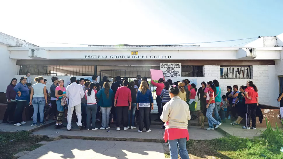 EN LA PUERTA. Enfurecidos por la ola delictiva dentro del edificio escolar, los padres de alumnos reaccionaron para exigir la presencia de la Policía. LA GACETA / FOTO DE JORGE OLMOS SGROSSO