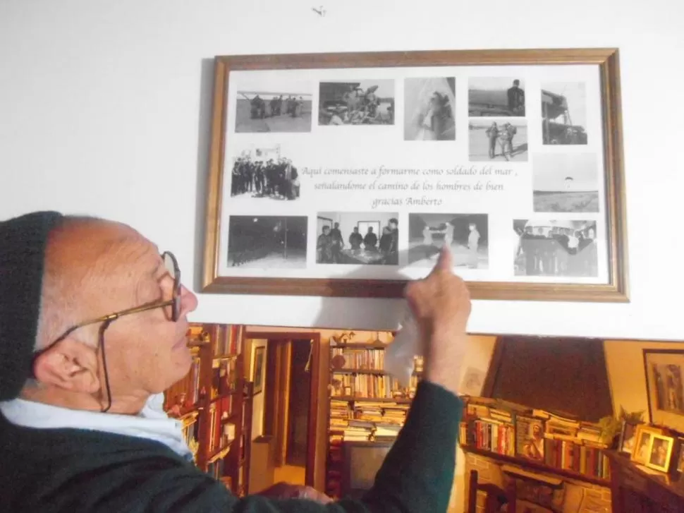 EN LA CASA DE MAR DEL PLATA. Alejandro Ambertín, en su biblioteca, muestra un cuadro con fotografías de sus épocas de marino en la Armada. FOTOS GENTILEZA LA GACETA MARINERA 