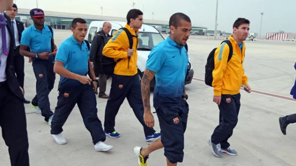 RECIÉN LLEGADO. Alves y Messi encabezan la fila de jugadores de Barcelona que descienden del avión que los llevó a Bilbao. 