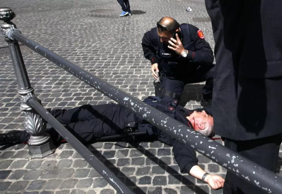 POLICÍA HERIDO. Un Carabinero yace en el suelo después de los disparos. REUTERS