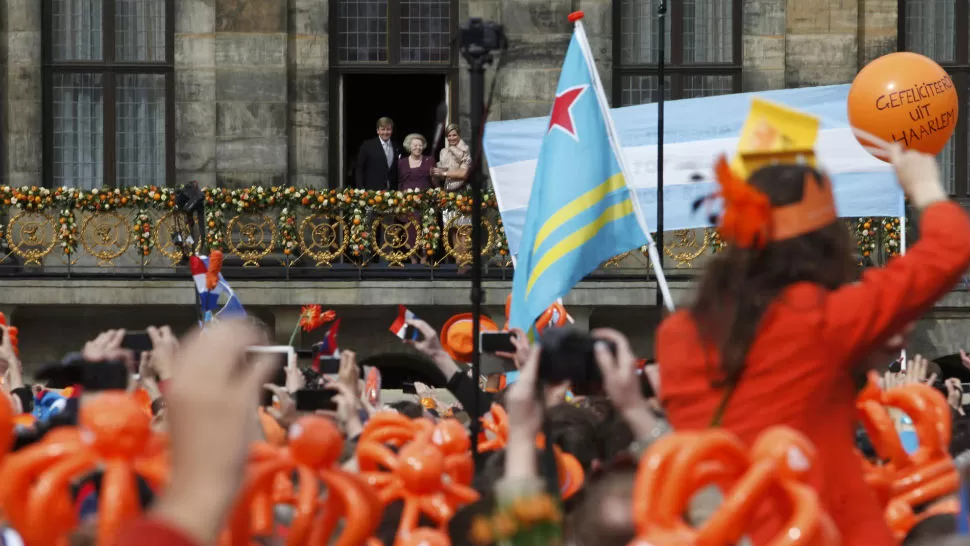 REINA. Una bandera de Argentina mientras Máxima saluda. REUTERS