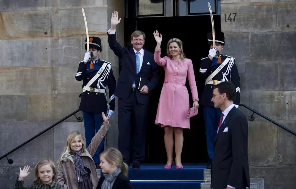 TIEMPO BISAGRA. Los reyes y sus hijas saludan luego del último festejo. Guillermo, agenda en mano, comenzó luego su primer día como Jefe de Estado. EFE - REUTERS  
