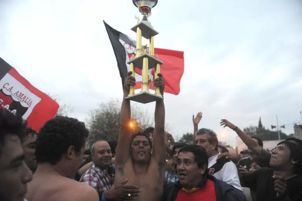 UN LEON. Rubén Toledo, que lleva la copa en la vuelta olímpica, sacó a relucir toda su experiencia en el fondo de los villeros que vivió su tarde soñada.  