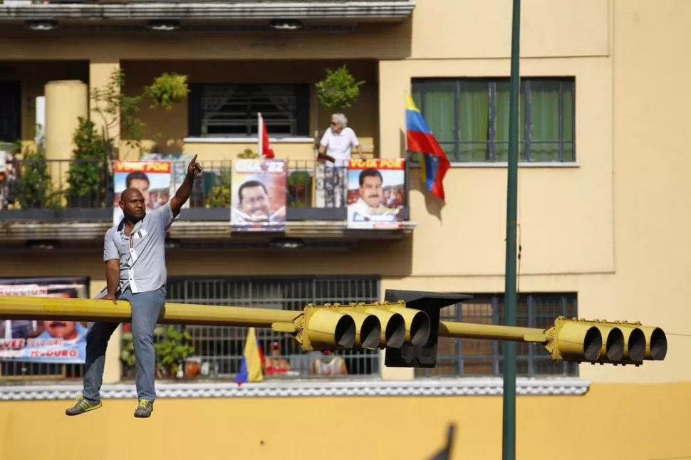 EN CUALQUIER LADO. Los seguidores del chavista Nicolás Maduro llenaron las calles de Caracas el Día del Trabajador, e incluso se subieron a semáforos. REUTERS