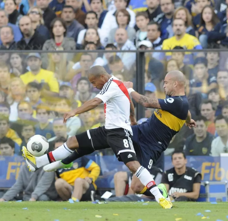 AYUDANDO EN LA RECUPERACIÓN. El uruguayo Carlos Sánchez se lleva la pelota, pese al asedio de su compatriota Santiago Silva. El Pelado logró el empate tras una buena combinación ofensiva de Boca. 