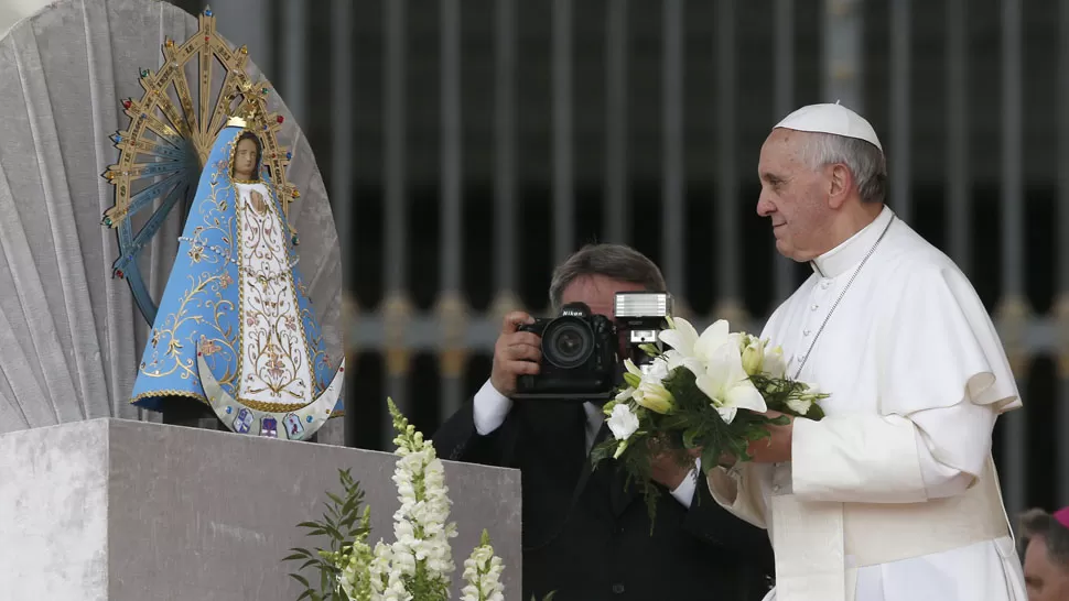 HONORES. El Papa dejó un ramo de flores y tocó la imagen de la patrona de la Argentina. REUTERS