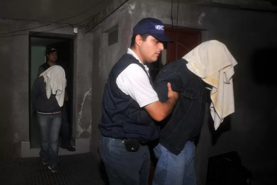 A LA CELDA. Los policías proceden a la detención de los hermanastros Juan Pajol, de 40 años, y Aníbal Albornoz, de 26 años, por homicidio. LA GACETA / FOTO DE DIEGO ARAOZ