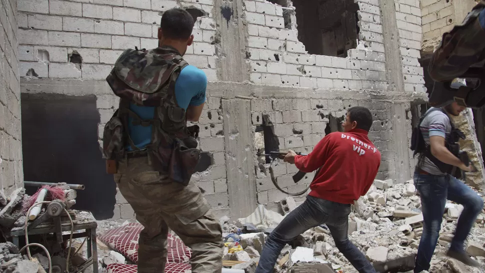 COMBATE. Soldados opositores entran a los tiros a una casa en la ciudad siria de Der al Zor. REUTERS