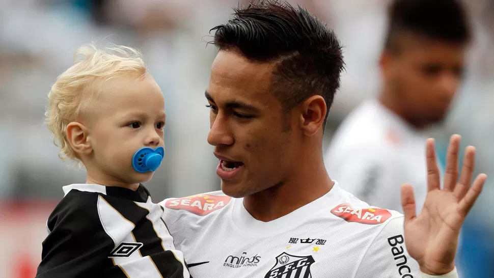 ADIOS. El crack brasileño, aquí junto a su hijo Davi Lucca, podría jugar el domingo su último partido con su equipo. REUTERS