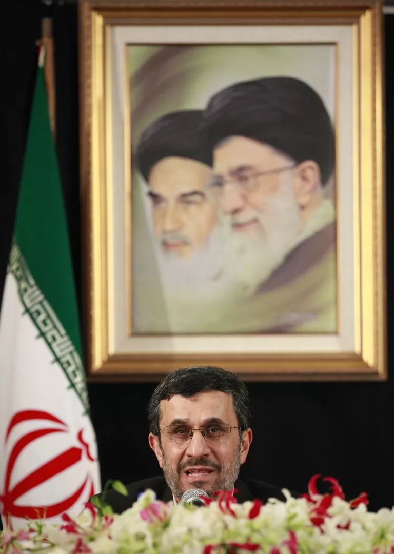 DEBAJO DEL PODER RELIGIOSO. Ahmadinejad habla en 2012 con el retrato de los ayatollah Ruhollah Khomeini y Alí Khamenei detrás. REUTERS