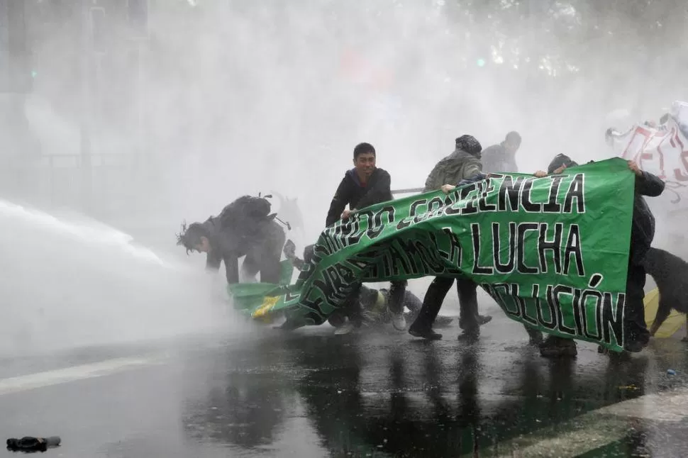 EN SANTIAGO. Un grupo de estudiantes es contenido con chorros de agua, lanzado por un carro de Carabineros. REUTERS