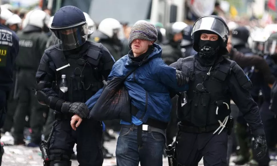 DETENIDO. La Policía alemana lleva apresado a un joven manifestante. REUTERS