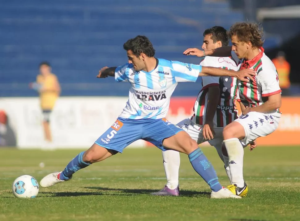 LA PELOTA ES MÍA. Matías Ballini, que regresó ayer al primer equipo tras cumplir una fecha de suspensión, cubre el balón ante la llegada de dos rivales del local. FOTO DE MARCELO RUIZ (ESPECIAL PARA LA GACETA)