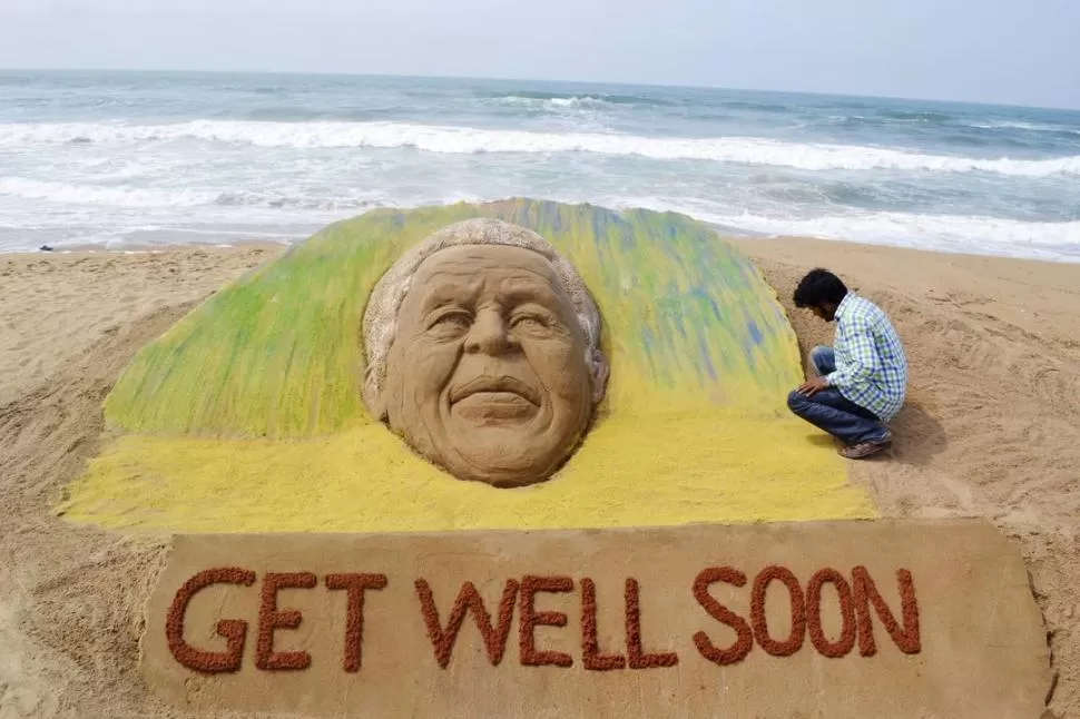 EN LA INDIA. Un artista plástico construyó una escultura de arena en una playa para pedir una pronta recuperación del ex presidente sudafricano. REUTERS