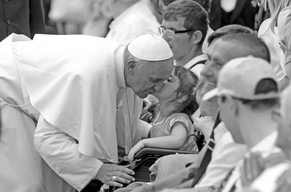 FUERA DE PROTOCOLO. El Papa besa a una niña luego de la misa. REUTERS 