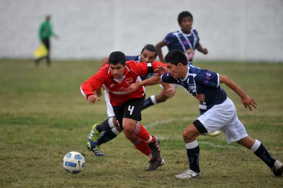 BUENA TAREA. Pablo González, de All Boys, se lleva la pelota ante la marca de Argañaraz, de San Juan. 