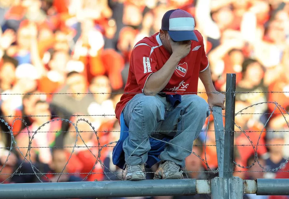 NO LO PUEDE CREER. Un hincha de Independiente llora desconsoladamente en medio del alambre de púas arriba del alambrado, el día del partido ante San Lorenzo. 