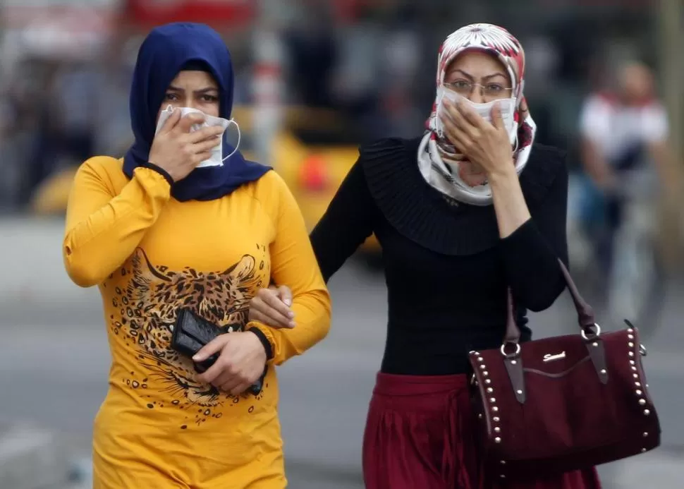 AFECTADAS. Dos mujeres respiran a través de mascarillas en Ankara. REUTERS
