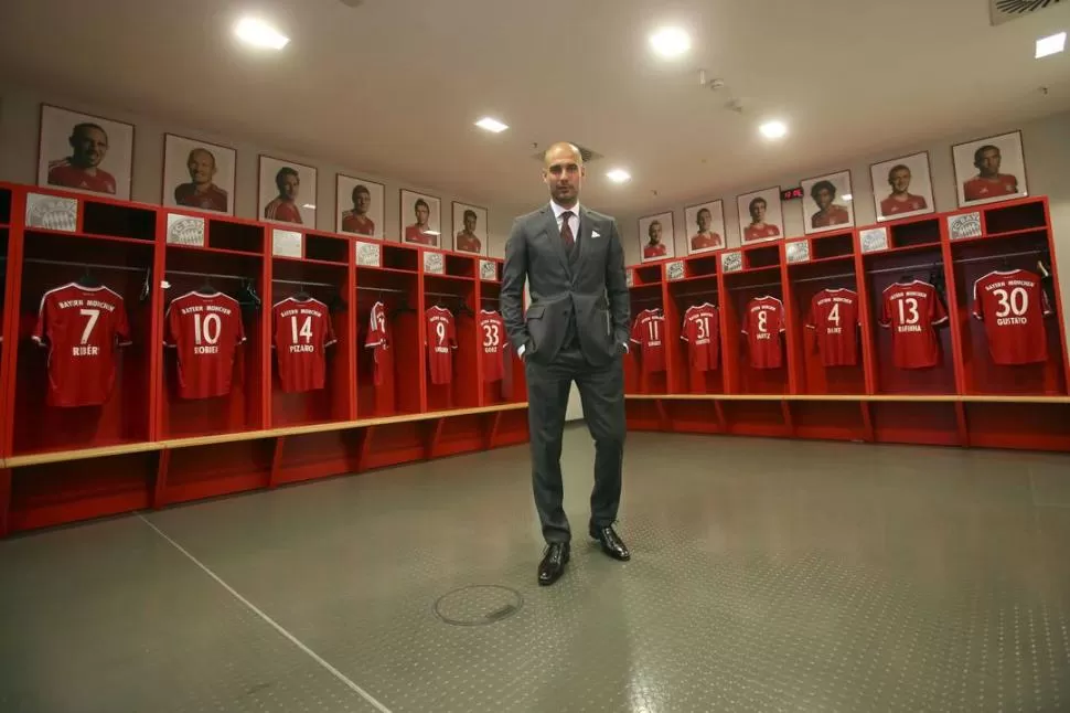 EL VESTUARIO. Guardiola posa en el vestidor de Bayern Munich en el Allianz Arena; atrás cuelgan las camisetas de los que serán sus nuevos jugadores a partir de la próxima temporada. 