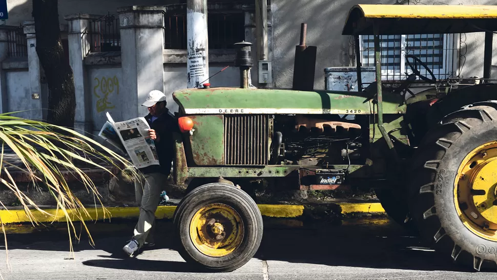 SIGUIENDO LA NEGOCIACIÓN. Un cañero lee LA GACETA, parado delante del tractor. Los productores amenazan con recrudecer la protesta. LA GACETA / FOTO DE JORGE OLMOS SGROSSO