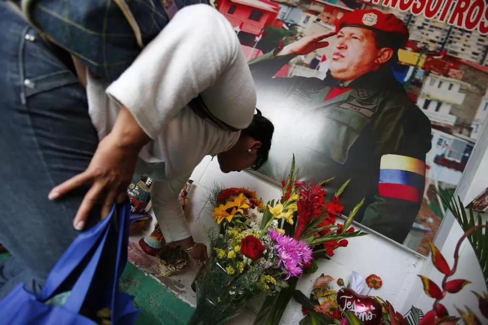 HOMENAJE CIUDADANO. Una mujer deposita flores en el ingreso del museo militar en Caracas, donde fueron depositados los restos de Hugo Chávez. REUTERS