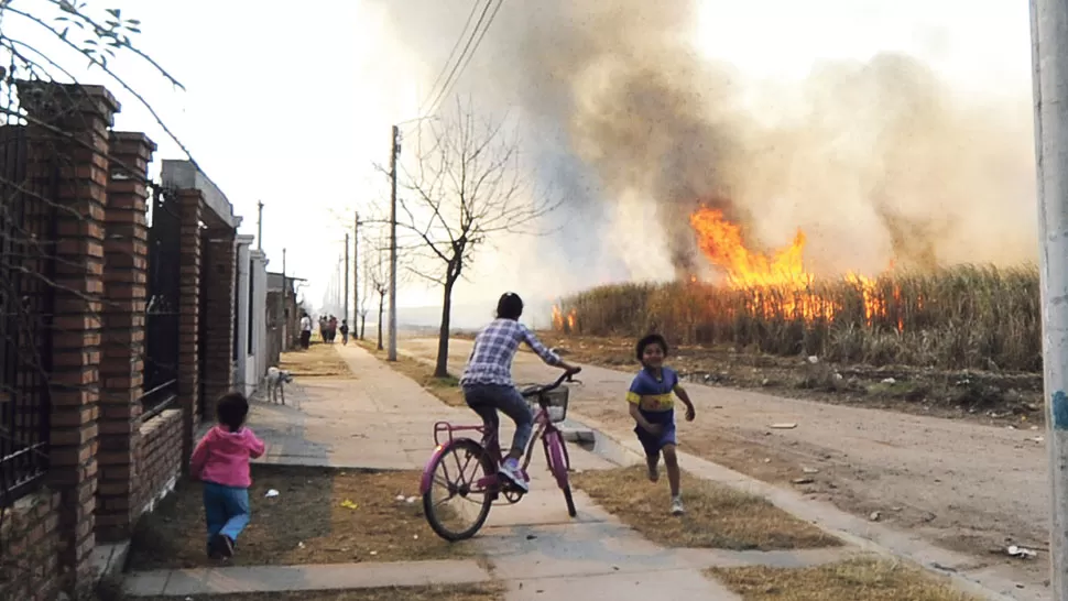PREOCUPACIÓN VECINAL. Pobladores de Arcadia observan cómo el fuego consume la caña, cerca de sus viviendas, a la vera de la ruta nacional 38. LA GACETA / FOTO DE OSVALDO RIPOLL