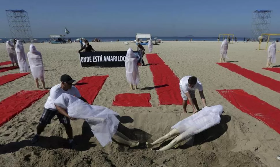 PLAYA. Maniquíes que representan a desaparecidos se colocan en la arena. REUTERS