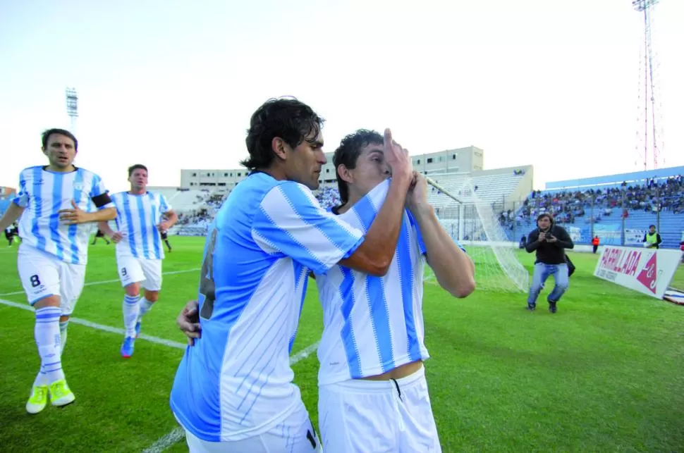 EL FESTEJO. Luis Rodríguez se besa el escudo de la camiseta luego de su gol, mientras recibe la felicitación de Montiglio. FOTOS DE JUAN FERNáDEZ (ESPECIAL PARA LA GACETA)