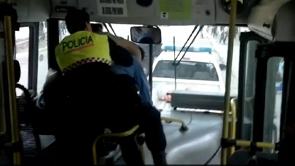 MOMENTO TENSO. Los hombres se golpean, mientras los pasajeros gritan y un policía trata de separarlos. CAPTURA DE VIDEO