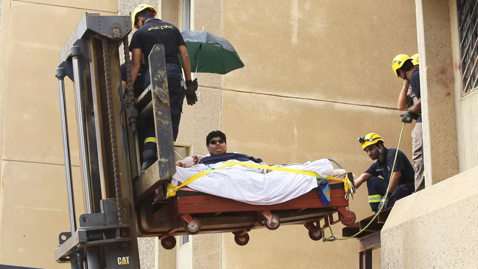VIDA EN PELIGRO. Los rescatistas usaron una grúa y una cama especial para trasladarlo al aeropuerto. REUTERS