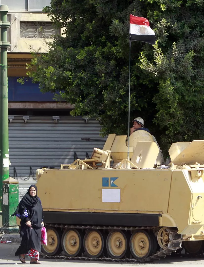 MILITARES EN LAS CALLES. Una mujer musulmana pasa frente a un tanque cerca de la cairota plaza Tahrir.  REUTERS