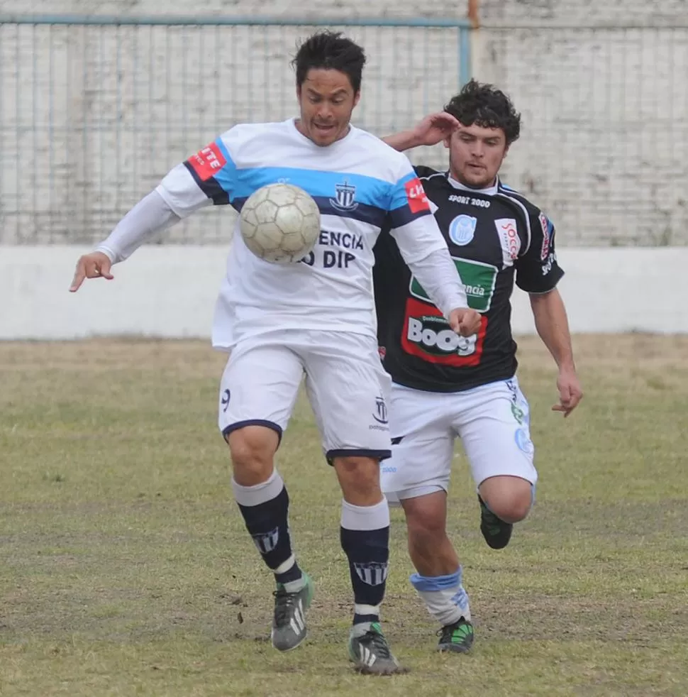 ¡ES MÍA! Andrés Quintana, de Brown, se lleva la pelota antes la marca de José Loretto, de Atlético Concepción. 