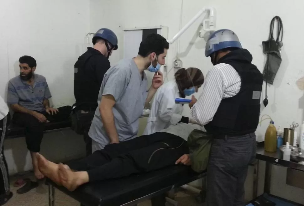 EN EL TERRENO. Los expertos de la ONU revisan ayer a un afectado por el presunto ataque con armas químicas, en un hospital cercano a Damasco. REUTERS