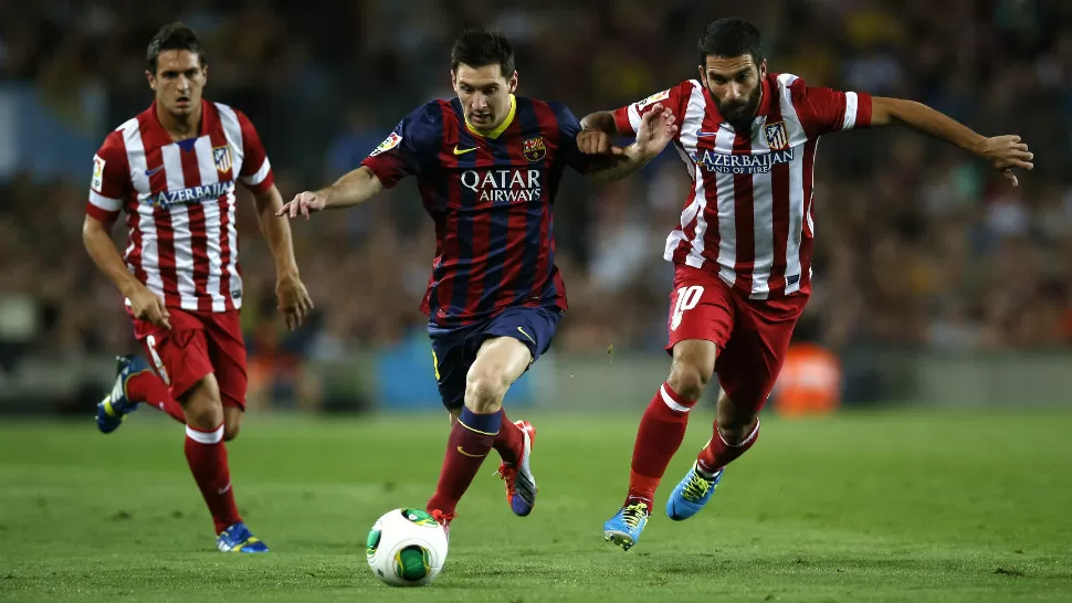 BAJO PRESION. Lionel Messi intenta dejar atrás la marca madrileña. El rosarino no estuvo en su mejor forma y falló un penal a pocos minutos del final. REUTERS