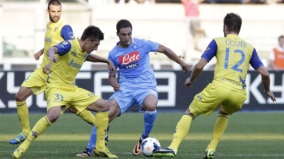 LESIONADO Y TODO..... Pipita maniobra ante dos rivales con la camiseta de Napoli. FOTO REUTERS