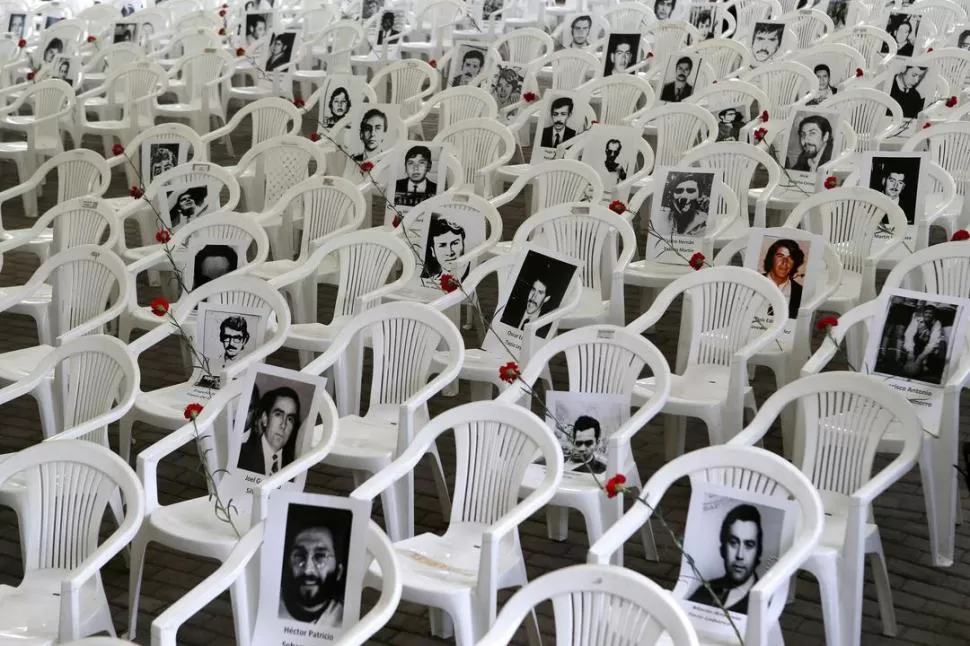 ACTO. En el antiguo centro de tortura, Villa Grimaldi, en Santiago, se ven las fotos de desaparecidos chilenos. FOTO DE REUTERS