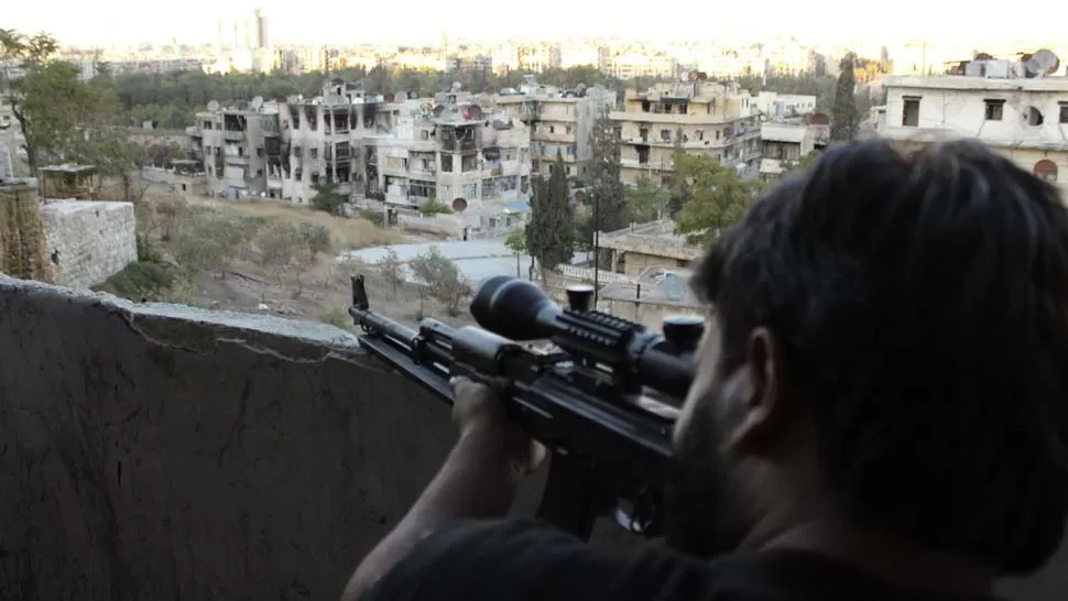 EN GUERRA. Un francotirador del ejército opositor al gobierno sirio vigila las calles de Alepo. REUTERS
