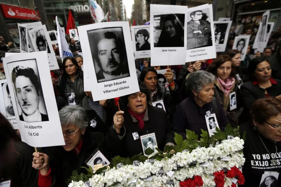 ACTO. La mayoría de los chilenos que marcharon llevaban fotos de desparecidos o muertos por la represión. REUTERS