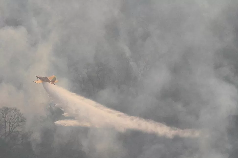 AGUA. Un gigantesco chorro se desprende del avión hidrante que ayer sobrevoló las montañas durante todo el día para tratar de controlar las llamas; mientras por tierra los guardaparques y bomberos aportaban su esfuerzo.  