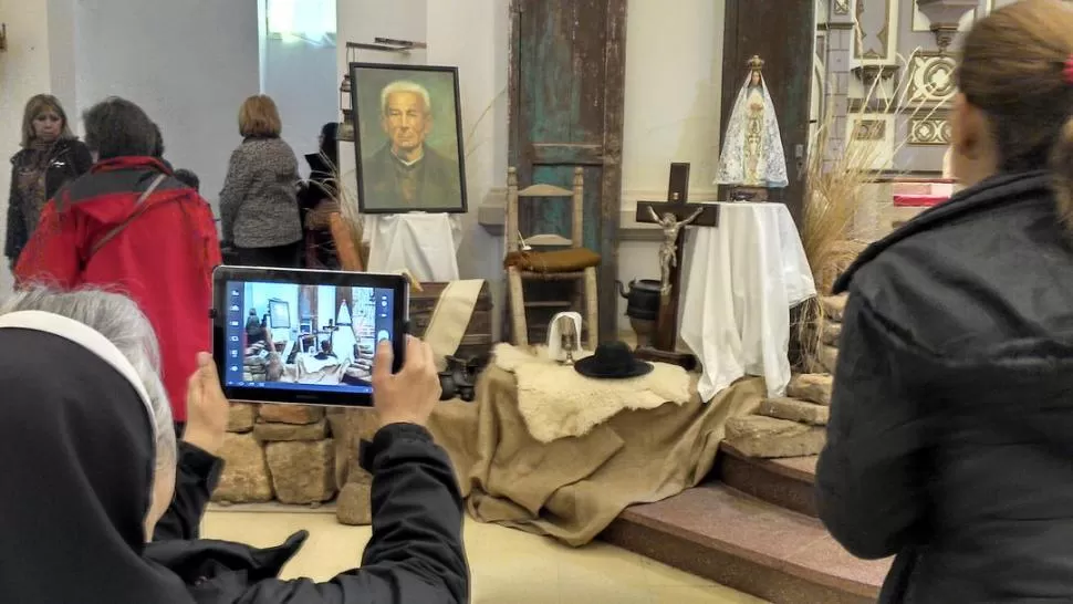 MONJA TECNO. Una religiosa le saca una foto con una tablet a las pertenencias de Brochero: el sombrero, el cáliz y el poncho, entre otras cosas. 