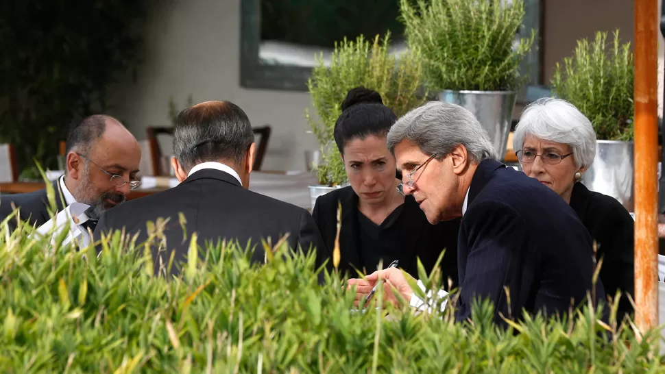 DIALOGO Kerry (derecha) negocia con el ruso Lavrov (de espaldas) en Ginebra. AFP