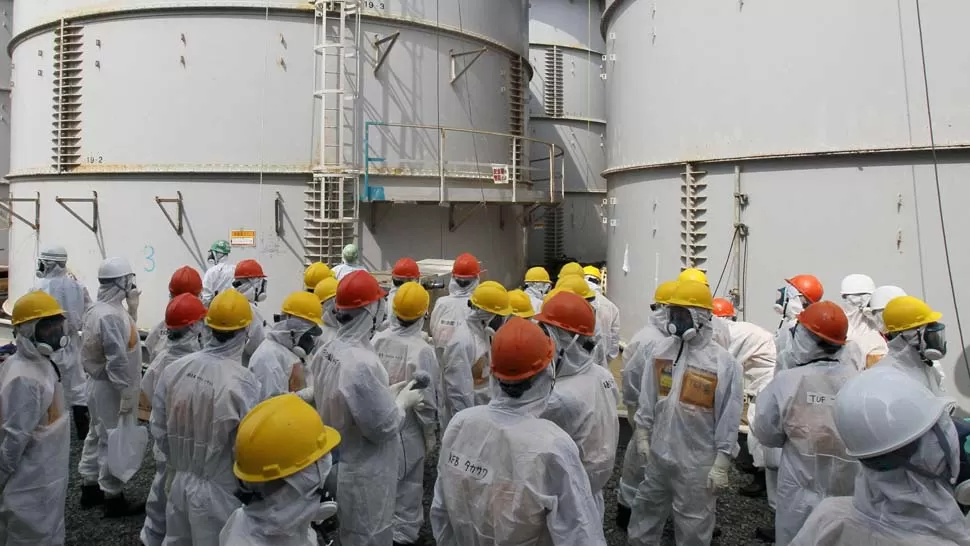 SEGURIDAD. Trabajadores de la planta de Fukushima inspeccionan uno de los tanques con agua contaminada. REUTERS